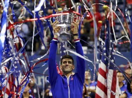 Novak Djokovic of Serbia holds up the U.S. Open trophy after defeating Roger Federer of Switzerland in their men's singles final match at the U.S. Open Championships tennis tournament in New York, September 13, 2015. REUTERS/Mike Segar