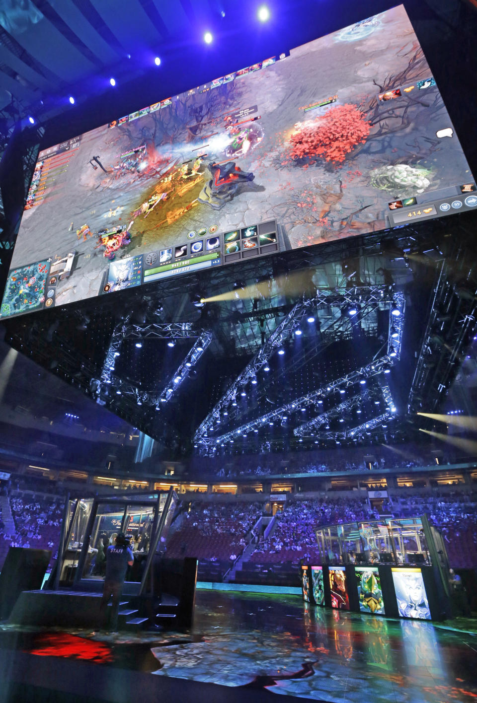 A giant monitor shows the game as fans look on at KeyArena during the International Dota 2 Championships Wednesday, Aug. 9, 2017, in Seattle. Members of the five-person eSport teams each select fantasy-world hero characters and the teams then face off for control of the game world's map. The championship, pitting 16 teams against each other for $24 million in prize money, runs through Saturday. (AP Photo/Elaine Thompson)