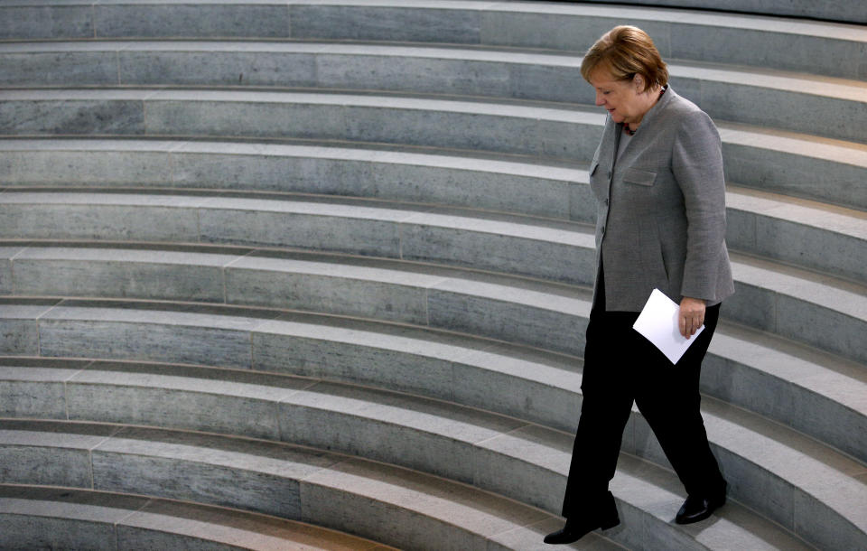 German Chancellor Angela Merkel walks down stairs as she arrives for a meeting with relatives of German soldiers and police officers in Berlin, Germany, Tuesday, Dec. 11, 2018. (AP Photo/Michael Sohn)