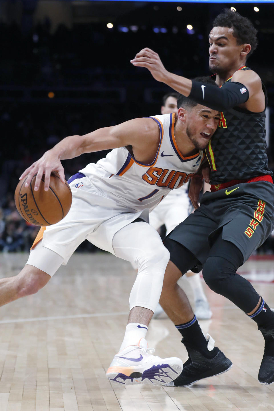 Phoenix Suns guard Devin Booker (1) drives against Atlanta Hawks guard Trae Young (11) in the first half of an NBA basketball game Tuesday, Jan. 14, 2020, in Atlanta. (AP Photo/John Bazemore)