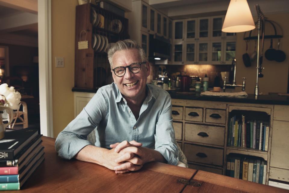 Michael Ritchie smiles sitting at a table.