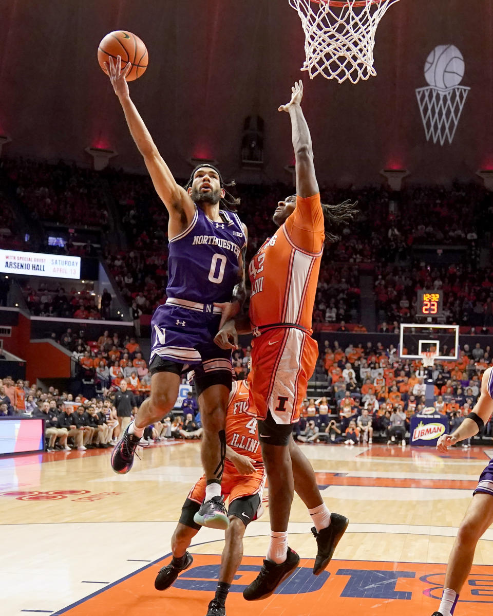 Northwestern's Boo Buie drives to the basket as Illinois' Dain Dainja defends during the first half of an NCAA college basketball game Tuesday, Jan. 2, 2024, in Champaign, Ill. (AP Photo/Charles Rex Arbogast)