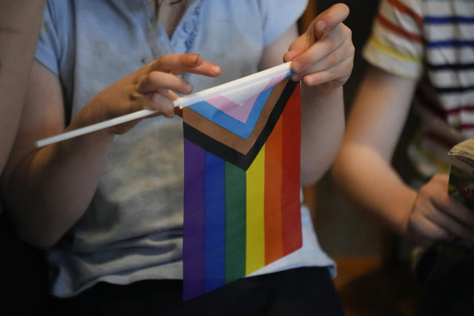 A person holds a Pride Flag outside the House chambers before a legislative session, Monday, Feb. 26, 2024, in Nashville, Tenn. (AP Photo/George Walker IV)