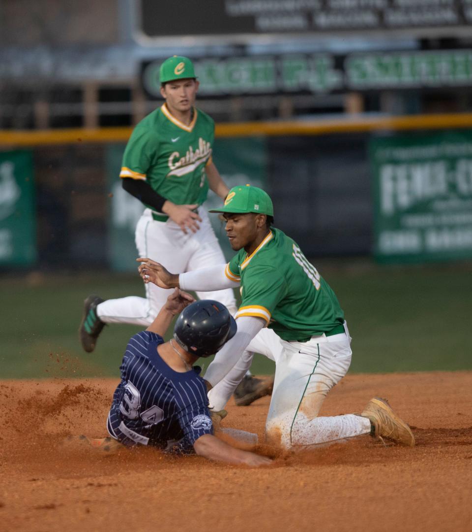 Catholic's Chris Rembert (No. 10) tags Central's Justin Smarr (No. 34) out for a second during Wednesday's game against the Jaguars. The Crusaders blanked the Jaguars 15-0 after four innings.