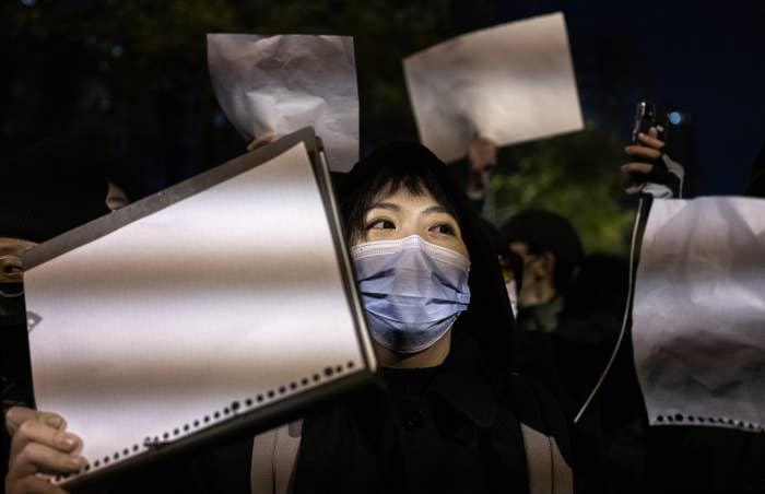 Protesters hold up a white piece of paper against censorship as they march during a protest against China's strict COVID measures on Nov. 27, 2022, in Beijing.