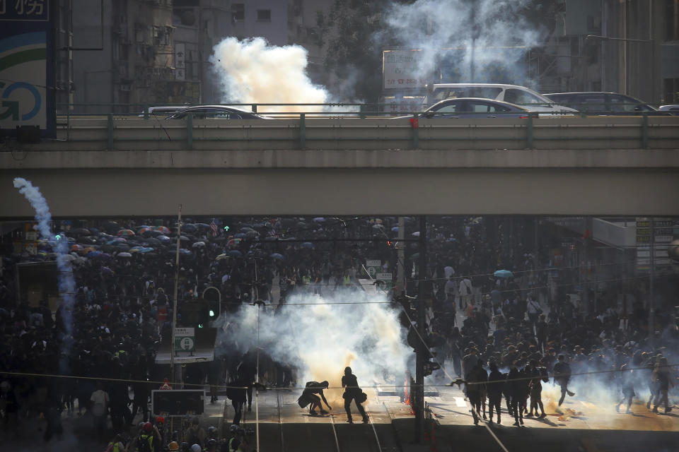 Demonstrators react as police officers fire tear gas during a protest in Hong Kong, Saturday, Nov. 2, 2019. Defying a police ban, thousands of black-clad masked protesters are streaming into Hong Kong's central shopping district for another rally demanding autonomy in the Chinese territory as Beijing indicated it could tighten its grip. (AP Photo/Kin Cheung)