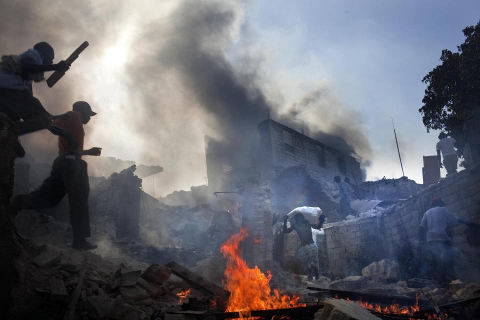 Young men run through the rubble during a looting spree in Port-au-Prince's downtown business district.