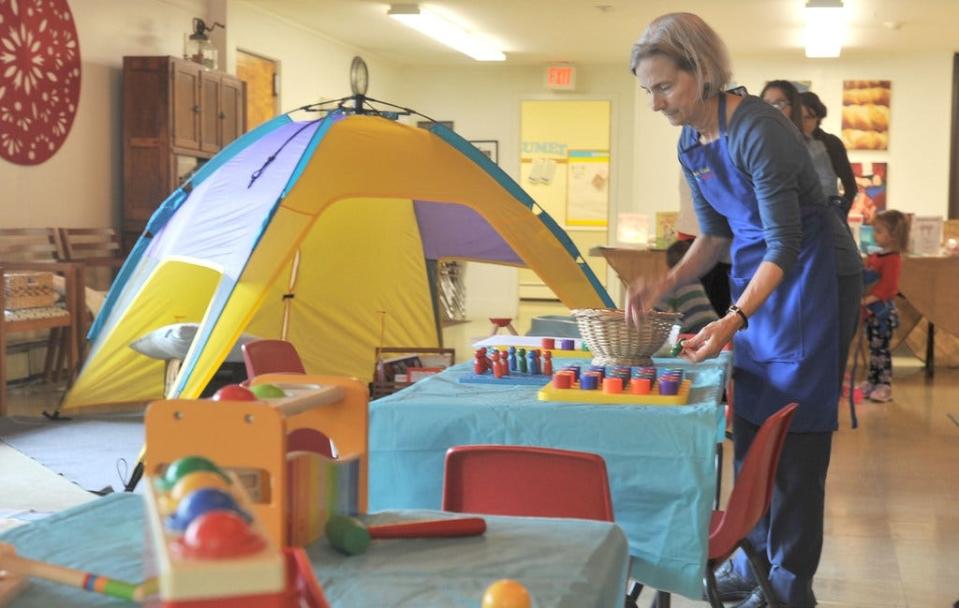 Deb Willsea straightens up some of the play areas at the First Lutheran Church in West Barnstable, which is home to the Cape Cod Toy Library. [Steve Heaslip/Cape Cod Times]