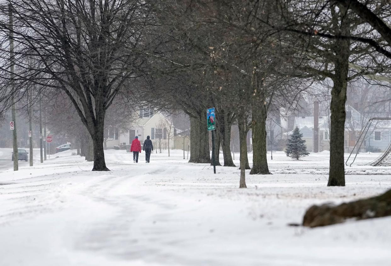 A couple walks around Westgate Park while snow starts to fall in Columbus on Jan. 24. Cold weather remains around Greater Columbus.