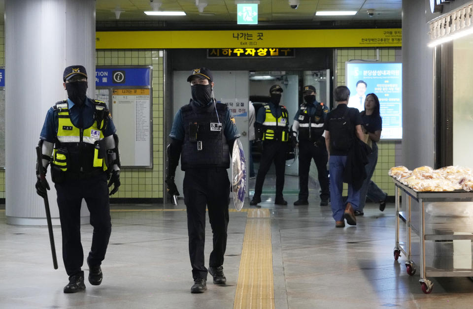 Police officers patrol at Ori subway station following Thursday's attack in Seongnam, South Korea, Friday, Aug. 4, 2023. South Korean police detained a man suspected of stabbing a high school teacher with a knife Friday in the city of Daejeon. The stabbing follows a separate, apparently random attack on Thursday in which 14 people were wounded near a busy subway station in Seongnam. (AP Photo/Ahn Young-joon)