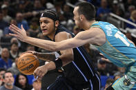 Orlando Magic forward Paolo Banchero, left, drives to the basket as Charlotte Hornets forward Aleksej Pokusevski (17) defends during the first half of an NBA basketball game, Tuesday, March 19, 2024, in Orlando, Fla. (AP Photo/Phelan M. Ebenhack)