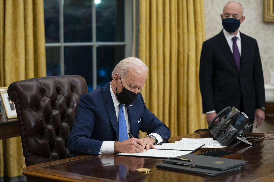 FILE - In this Tuesday, Feb. 2, 2021, file photo, Secretary of Homeland Security Alejandro Mayorkas looks on as President Joe Biden signs an executive order on immigration, in the Oval Office of the White House in Washington. Biden, under political pressure, agreed to admit four times as many refugees this budget year as his predecessor did, but resettlement agencies concede the number actually allowed into the U.S. will be closer to the record-low cap of 15,000 set by former President Donald Trump. (AP Photo/Evan Vucci, File)