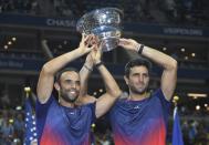 Juan Sebastian Cabal, left, and Robert Farah, both of Colombia, hold up the championship trophy after defeating Marcel Granollers, of Spain, and Horacio Zeballos during the men's doubles final of the U.S. Open tennis championships Friday, Sept. 6, 2019, in New York. (AP Photo/Sarah Stier)