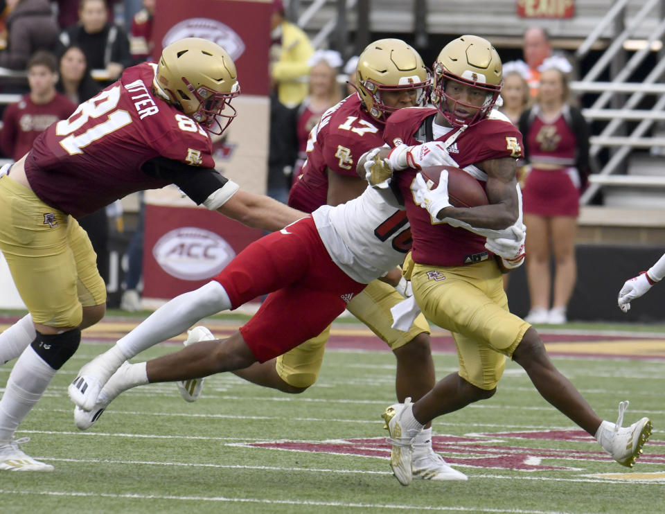 Boston College wide receiver Zay Flowers is grabbed from behind by Lousiville's Benjamin Perry during the fourth quarter of an NCAA college football game Saturday, Oct. 1, 2022, in Boston. (AP Photo/Mark Stockwell)
