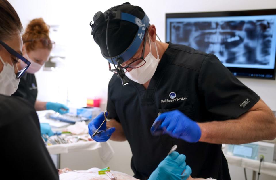 Dr. Frederick A. Hartman, an oral surgeon and president of the Rhode Island Dental Association, performs surgery on a patient at his East Providence office.