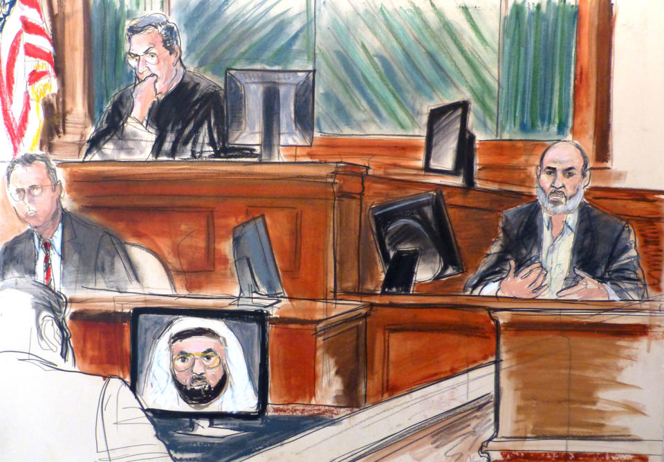 In this courtroom sketch Osama bin Laden's son-in-law, Sulaiman Abu Ghaith, right, testifies at his trial Wednesday, March 19, 2014, in New York, on charges he conspired to kill Americans and aid al-Qaida as a spokesman for the terrorist group. Listening to testimony are Judge Lewis Kaplan, upper left, and clerk Andrew Mohan, center left, as an image of Khalid Sheik Mohammed, the self-professed architect of the Sept. 11 attacks, appears on a video monitor. In his surprise testimony, Abu Ghaith recounted the night of the Sept. 11, 2001, attacks, when bin Laden sent a messenger to drive him into a mountainous area for a meeting inside a cave in Afghanistan. (AP Photo/Elizabeth Williams)