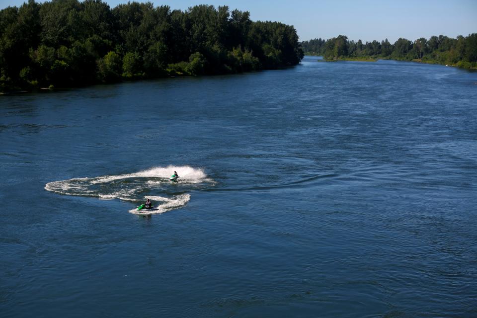 Two people on personal watercraft ride in the Willamette River near Union Street Railroad Bridge in Salem, Ore., on June 22.