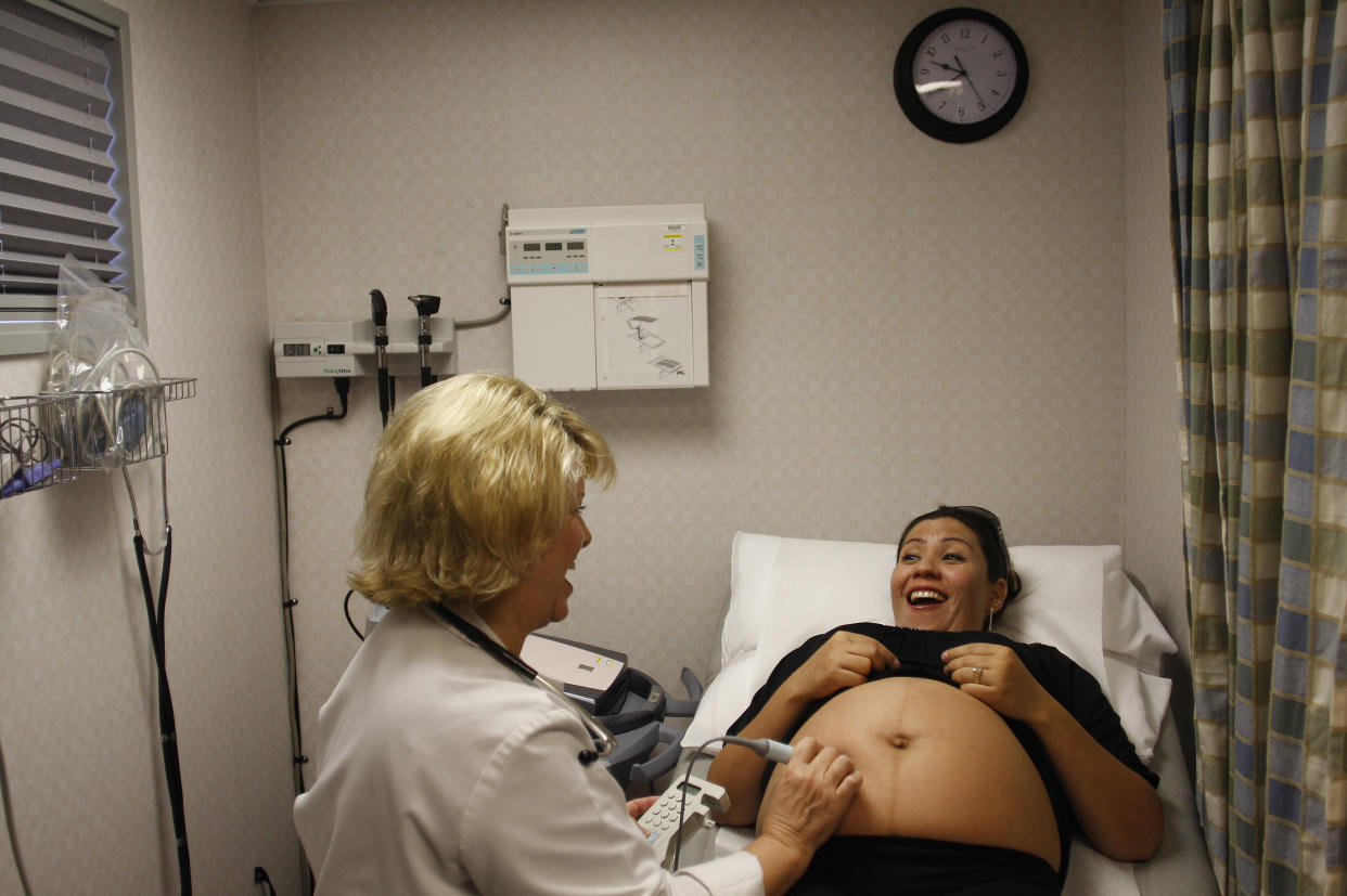 Elisama Martinez receives an ultrasound by nurse practitioner Gail Brown during a prenatal exam at the Maternity Outreach Mobile in Phoenix, Arizona October 8, 2009. The maternity outreach program helps uninsured women living in the Phoenix metropolitan area receive the proper treatment and health care during and after their pregnancy. The Maternity Outreach Mobile is equipped with two exam rooms, an ultrasound machine, an external fetal monitor, a laboratory and offers pregnancy tests, referrals and immunization for children. REUTERS/Joshua Lott (UNITED STATES - Tags: HEALTH SOCIETY)