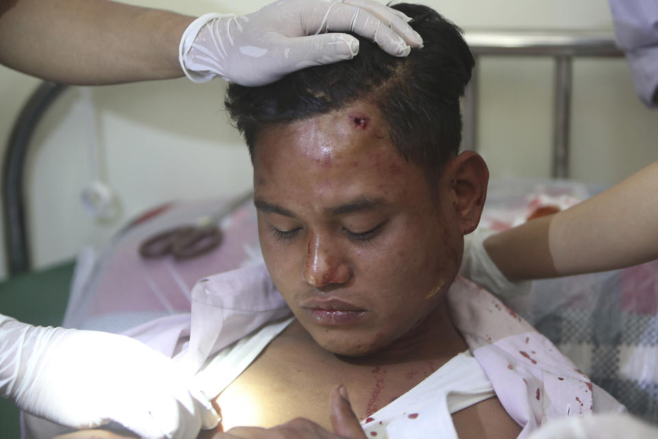 Paramedics tend to an injured protester during a demonstration against the military coup in Mandalay, Myanmar, Friday, Feb. 26, 2021. Security forces in Myanmar's largest city on Friday fired warning shots and beat truncheons against their shields while moving to disperse more than 1,000 anti-coup protesters. (AP Photo)