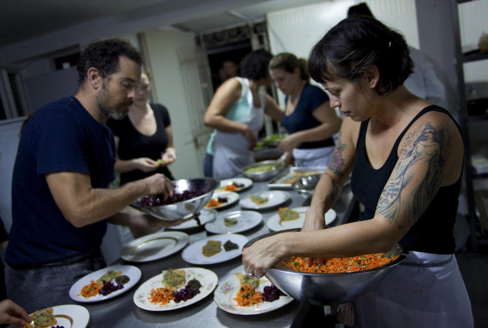 In this Dec. 7, 2012 photo, U.S. chefs Melissa Hernandez, right, and Charlie Hallowell, left, prepare dinner for guests at the privately-run restaurant Le Chansonnier in Havana, Cuba. Hernandez and Hallowell visited Cuba as part of the "Planting Seeds" delegation that held give-and-take seminars with chefs and culinary students about slow food. They also put on two dinners including a rabbit-based meal at the privately run Le Chansonnier and toured nearby organic farms that grow pesticide-free produce. (AP Photo/Ramon Espinosa)