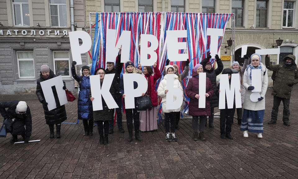 Members of pro-Kremlin organisations hold letters reading 'Hello Crimea' during celebration of the anniversary of Crimea annexation from Ukraine in 2014, in St. Petersburg, Russia, Thursday, March 18, 2021. Residents of cities in Crimea and Russia are holding gatherings to commemorate the seventh anniversary of Russia's annexation of the Black Sea peninsula from Ukraine. (AP Photo/Dmitri Lovetsky)
