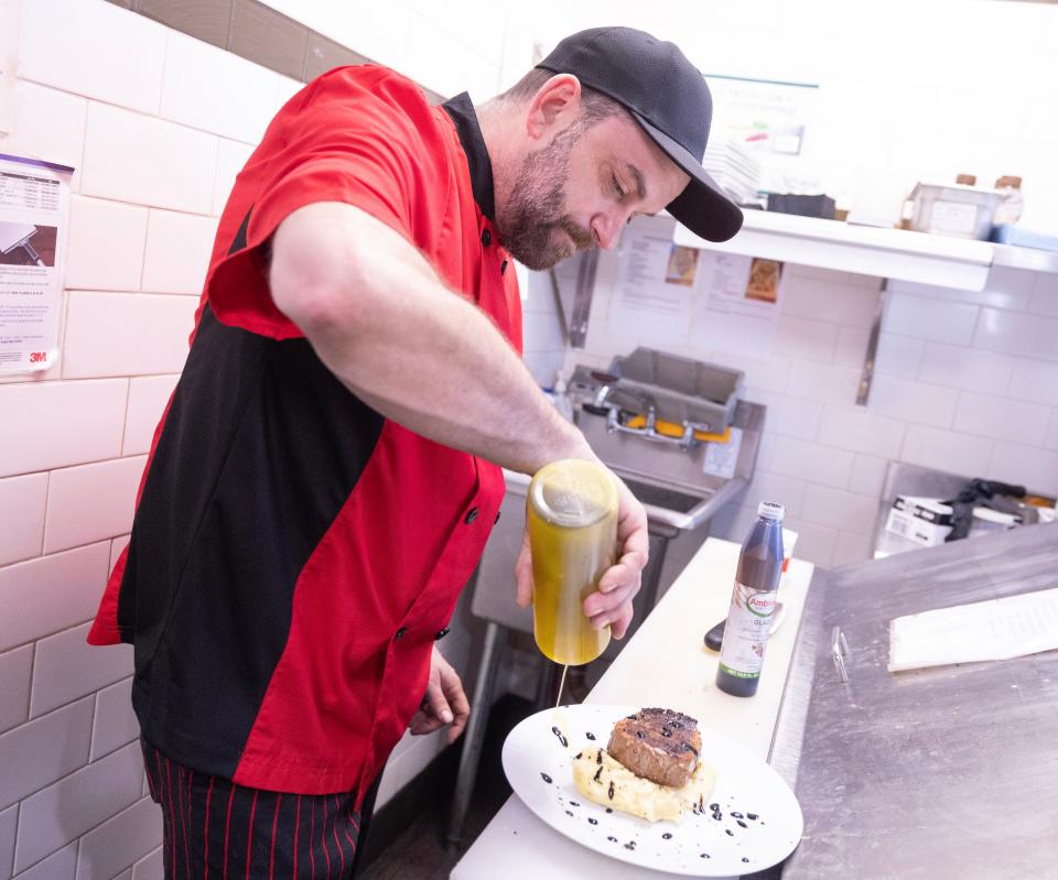 Social at the Stone House executive chef Jeff Herman drizzles extra virgin olive oil and a balsamic glaze on an 8-ounce fillet during evening service at the Massillon restaurant.