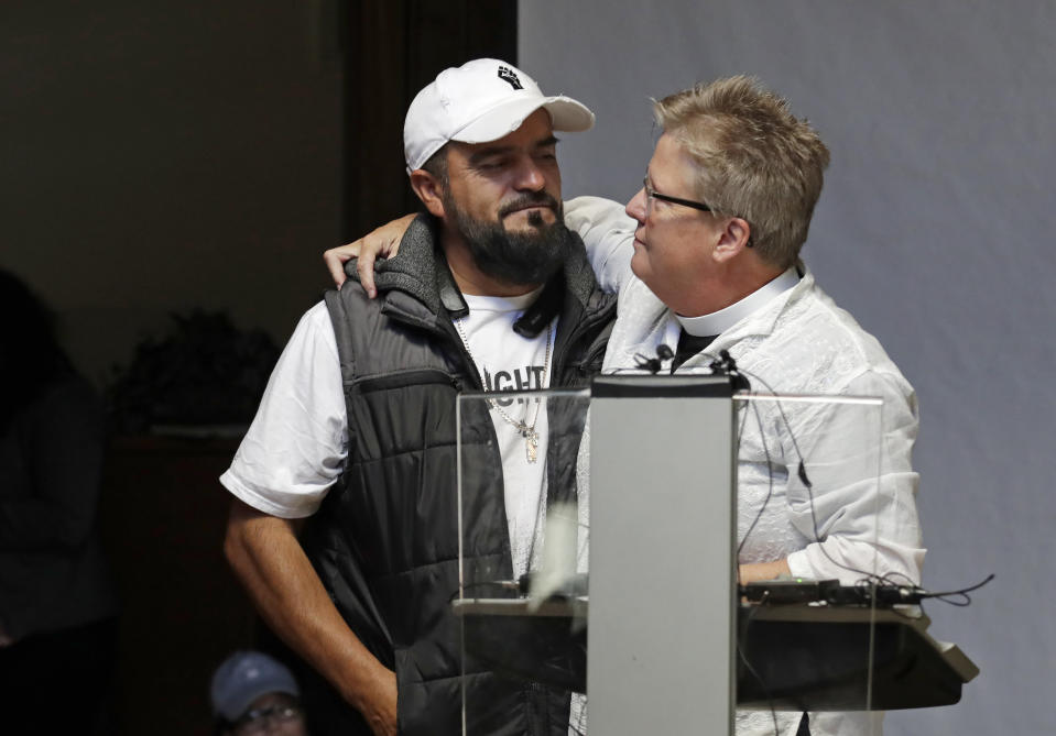 Jose Robles, left, is embraced by Gethsemane Lutheran Church Pastor Joanne Engquist inside Riverton Park United Methodist Church before Robles left to present himself to U.S. Immigration and Customs Enforcement officials Wednesday, July 17, 2019, in Tukwila, Wash. Robles, who has spent the past year inside a Seattle church to avoid being deported to Mexico, has been detained. The arrest Wednesday prompted protests from a crowd of supporters who had accompanied Robles to the agency. His deportation has temporarily been put on hold by a federal appeals court, and he has a pending visa application. (AP Photo/Elaine Thompson)