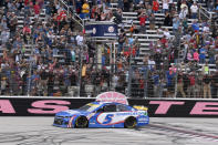 Kyle Larson (5) takes the checkered flag to win a NASCAR Cup Series auto race at Texas Motor Speedway Sunday, Oct. 17, 2021, in Fort Worth, Texas. (AP Photo/Randy Holt)
