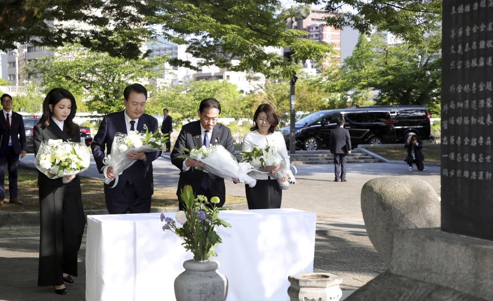 South Korean President Yoon Suk Yeol, center left, his wife Kim Keon Hee, left, Japan's Prime Minister Fumio Kishida and his wife Yuko Kishida lay flowers at the Monument in Memory of the Korean Victims of the A-bomb near the Peace Park Memorial in Hiroshima, Japan, Sunday, May 21, 2023, on the sidelines of the G7 Summit Leaders' Meeting. (Lim Hun-jung/Yonhap via AP)