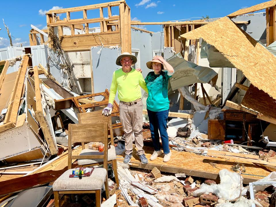John and Valerie Bernhart stand in what remains of their Blackburn Lane home following Wednesday's destructive storms. Though the home is a total loss, they are one of many families receiving continued support from churches, volunteers and neighbors.