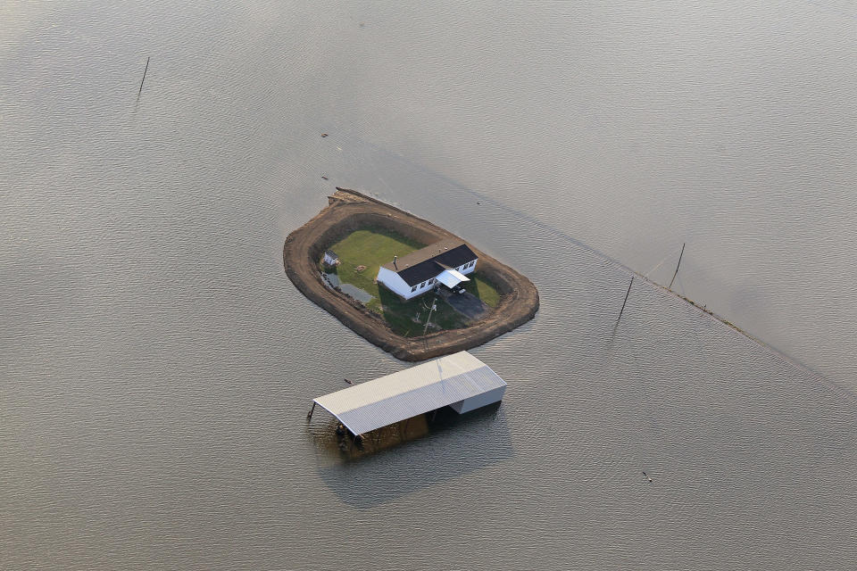 VICKSBURG, MS - MAY 18: A levee protects a home surrounded by floodwater from the Yazoo River May 18, 2011 near Vicksburg, Mississippi. The flooded Mississippi River is forcing the Yazoo River to top its banks where the two meet near Vicksburg causing towns and farms upstream on the Yazoo to flood. The Mississippi River at Vicksburg is expected to crest May 19. Heavy rains have left the ground saturated, rivers swollen, and have caused widespread flooding along the Mississippi River from Illinois to Louisiana. (Photo by Scott Olson/Getty Images)