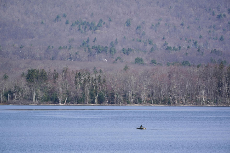 A rowboat makes its way on the surface of the Ashokan Reservoir in Olive, N.Y., Tuesday, April 5, 2022. As western regions contend with drier conditions, New York City is under fire for sometimes releasing hundreds of millions of gallons of water a day from the reservoir in the Catskill Mountains. The occasional releases, often around storms, have been used to manage water the reservoir's levels and to keep the water clear. But residents downstream say the periodic surges cause ecological harm along the lower Esopus Creek. (AP Photo/Seth Wenig)