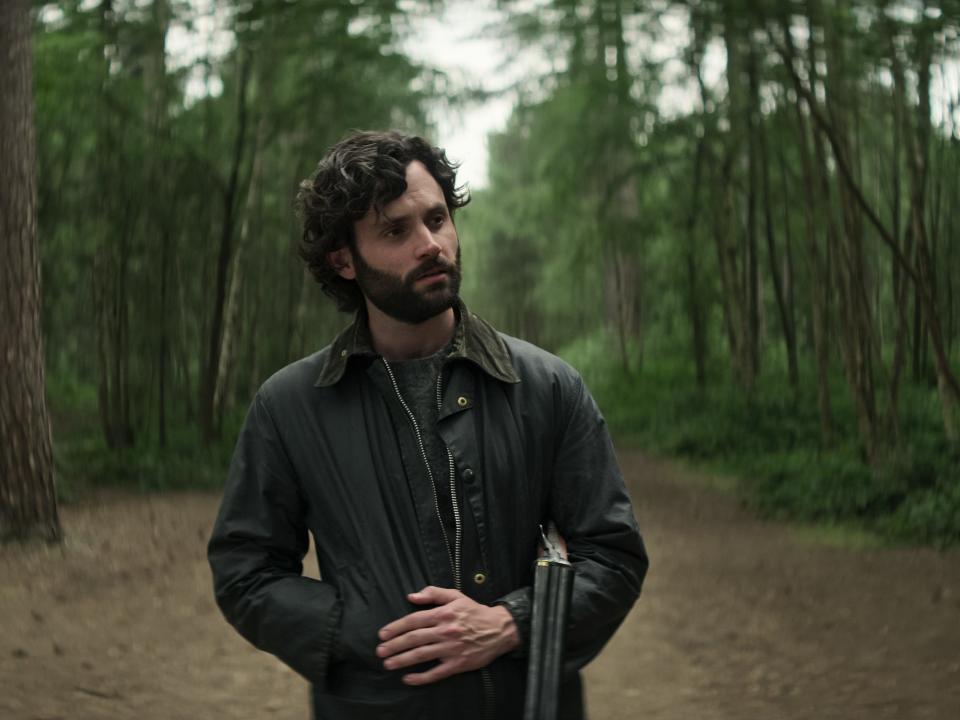 Joe (Penn Badgley) holds a gun in the woods in a scene from season 4 of "You."