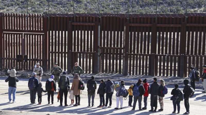 Chinese migrants stand in front of Border Patrol agents at the U.S.-Mexico border