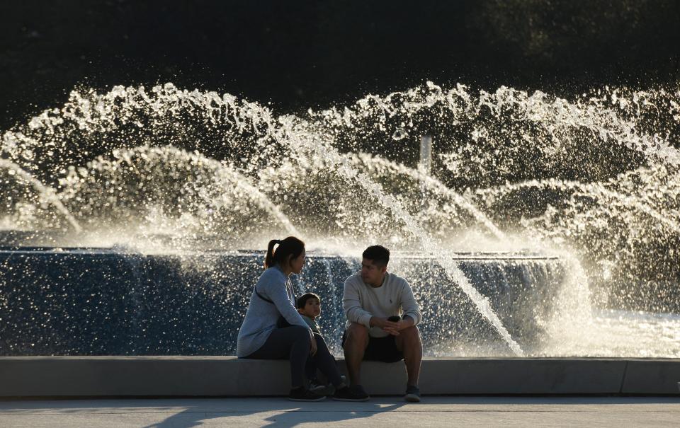 A family sits at the edge of Friendship Fountain when visitors made their way in February to the newly rebuilt Friendship Fountain on the Southbank of Jacksonville in an area called St. Johns River Park.