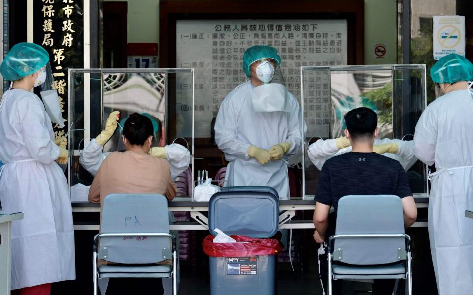 Medical staffers collect samples from local residents during a coronavirus testing drive at the Xindian District in New Taipei City - Sam Yeh / AFP