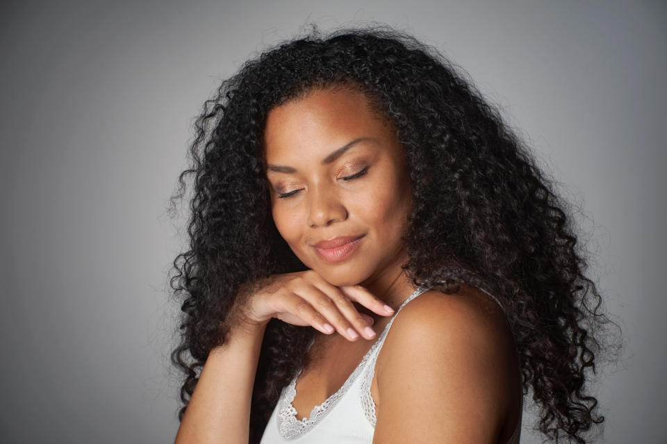 A woman smiling with her hand under her chin