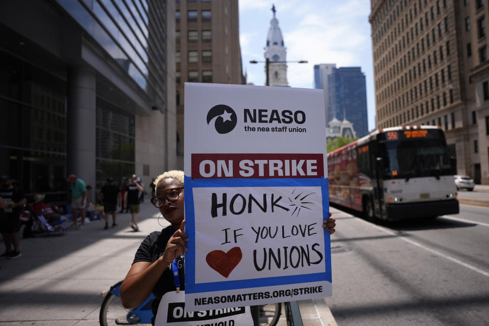 A demonstrator pickets in support of the National Education Association Staff Organization outside the Pennsylvania Convention Center, Friday, July 5, 2024, in Philadelphia. (AP Photo/Matt Slocum)