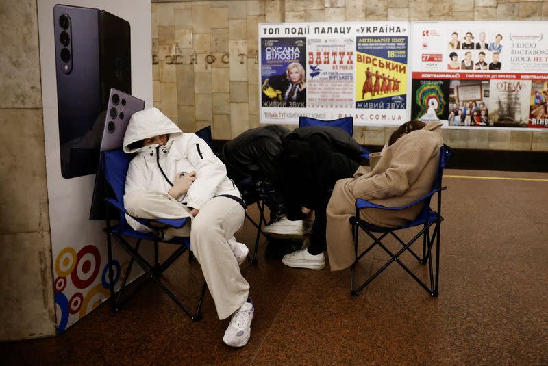 People take shelter in a metro station during a Russian missile strike, in Kyiv