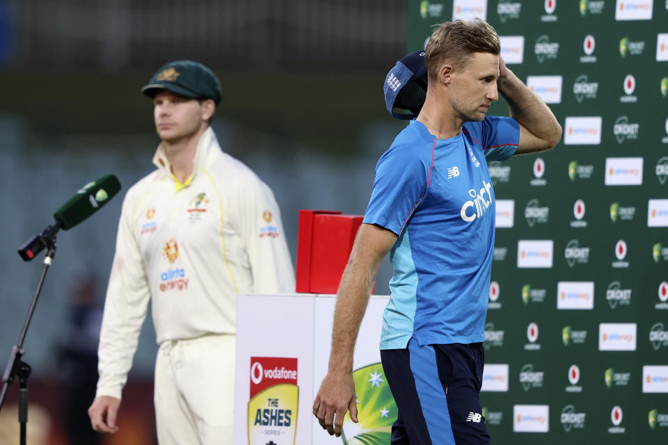 England's captain Joe Root, right, walks off the podium as his counterpart, Australia's Steve Smith steps up at the end of the fifth day of their Ashes cricket test match in Adelaide, Australia, Monday, Dec. 20, 2021. Australia wins the match by 275 runs. (AP Photo/James Elsby)