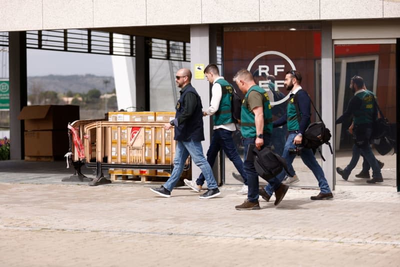 A Europol agent and several agents from the Guardia Civil's Central Operational Unit (UCO) leave the Royal Spanish Football Federation (RFEF) in Madrid. Spanish police raided offices of the nation's football federation RFEF and other properties, and carried out seven arrests, the Guardia Civil confirmed to dpa on Wednesday. Óscar J.Barroso/Afp7/Europapress/dpa