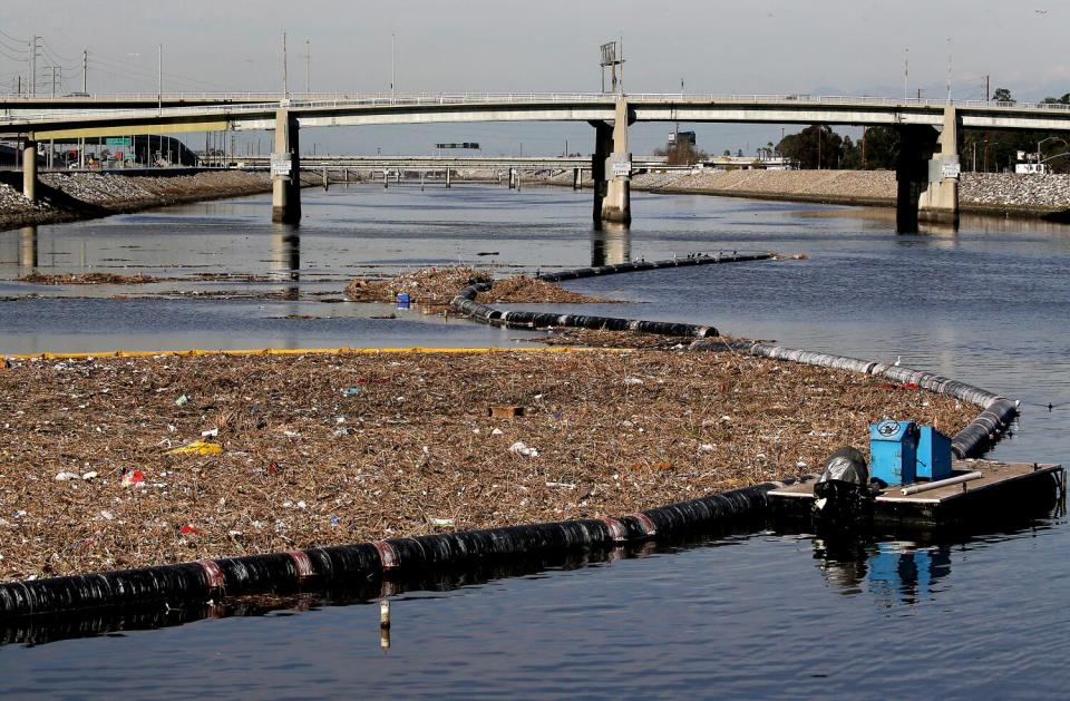 Garbage and debris collect behind a boom at the mouth of the Los Angeles