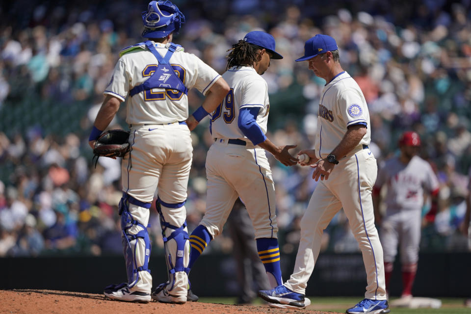 Seattle Mariners pitcher Keynan Middleton, center, is pulled by manager Scott Servais, right, during the seventh inning of a baseball game against the Los Angeles Angels, Sunday, July 11, 2021, in Seattle. (AP Photo/Ted S. Warren)