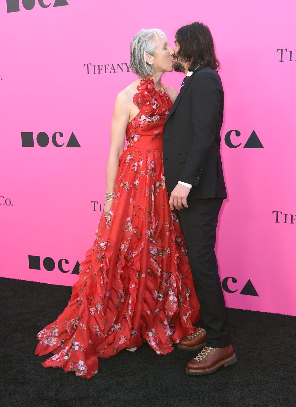 Between smiley photos on the red carpet, Reeves, right, and Grant took a moment for a quick smooch.