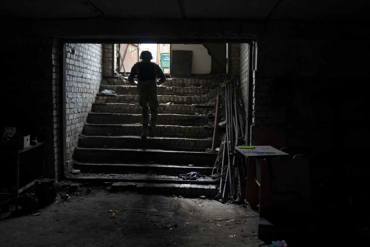 An Ukrainian serviceman walks out of a basement which, according to Ukrainian authorities, was used as a torture cell during the Russian occupation, in the retaken village of Kozacha Lopan, Ukraine, Saturday, Sept. 17, 2022. (AP Photo/Leo Correa)