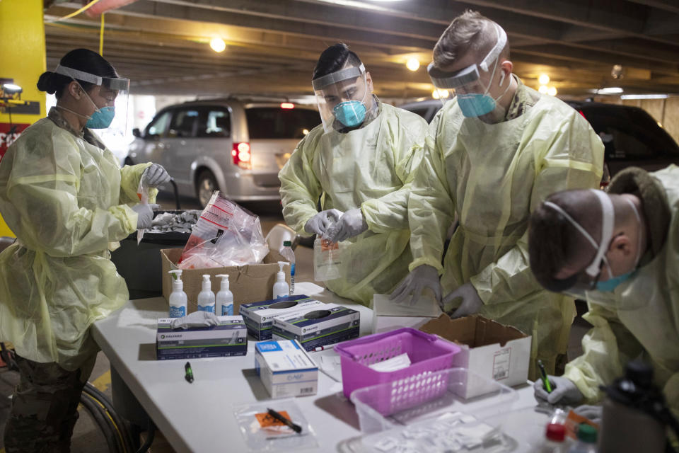 Miembros de la Guardia Nacional trabajan en un sitio de pruebas COVID-19 en un estacionamiento en el Centro Médico Wexner de la Universidad Estatal de Ohio en Columbus, Ohio, el 13 de enero de 2022. (Maddie McGarvey/The New York Times)