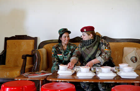 Iraqi Kurdish female fighter Haseba Nauzad (R), 24, and Yazidi female fighter Asema Dahir, 21, sit together to have their lunch at a site near the frontline of the fight against Islamic State militants in Nawaran near Mosul, Iraq, April 20, 2016. REUTERS/Ahmed Jadallah