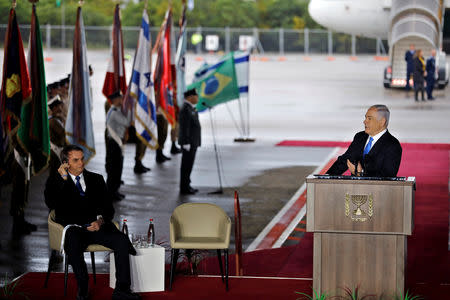 Israeli Prime Minister Benjamin Netanyahu speaks as Brazilian President Jair Bolsonaro sits nearby during a welcoming ceremony upon his arrival in Israel, at Ben Gurion International airport in Lod, near Tel Aviv, Israel March 31, 2019. REUTERS/Ronen Zvulun