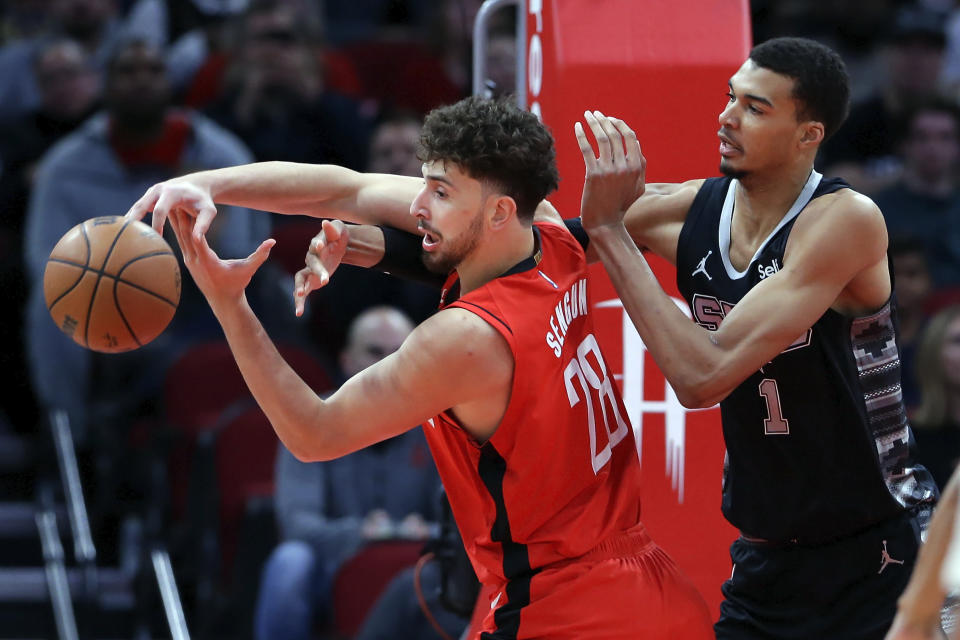 San Antonio Spurs center Victor Wembanyama (1) knocks the ball away from Houston Rockets center Alperen Sengun during the first half of an NBA basketball game, Monday, Dec. 11, 2023, in Houston. (AP Photo/Michael Wyke)