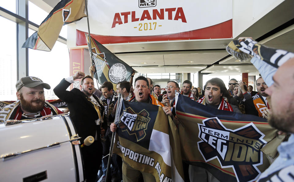 Un grupo de aficionados vitorea antes de una conferencia de prensa en la que se anunció que Atlanta tendrá un nuevo equipo de fútbol en la MLS, el miércoles 16 de abril de 2014, en Atlanta. (Foto AP/David Goldman)